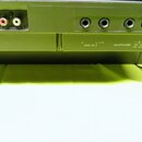 Detail zadní strany černého elektronického zařízení s řadou konektorů. Vlevo jsou tři cinchové vstupy s nápisy EXP PEDAL, R OPTIONAL IN L. Vpravo se…