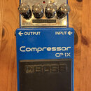 Modrý efekt pedál s nápisy Compressor a CP-1X. Na spodní části je černý gumový spínač s vyraženým logem BOSS. Horní ovládací panel obsahuje čtyři chr…