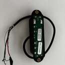 Černý humbucker s viditelným zeleným plošníkovým základem a připojenými vodiči. Na bílé nálepce je uveden text: 14HSG 20230621, SJB1B BRIDGE a SNO: 0…