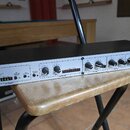 Rackové zařízení s bílým předním panelem a černým šasi. Na levé straně je logo dbx PROFESSIONAL PRODUCTS, vpravo nápis 286s Mic Preamp Processor. Pan…