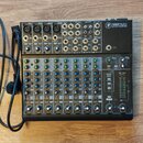 Mixovací pult s černým šasi a stříbrno-šedým horním panelem. V pravém horním rohu je logo značky a nápis 1202VLZ4 WITH ULTRA-LOW NOISE DESIGN. Zaříze…