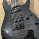 Černá elektrická kytara s glossy povrchem a dvěma humbuckery. Nástroj má jeden přepínač a dva oválné ovládací knoflíky. Na těle nejsou vidět žádná lo…