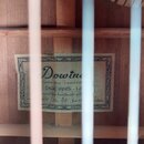 Fotografie zachycuje vnitřek akustického nástroje s viditelnými dřevěnými lištami a štítkem. Na štítku je nápis Dowine, Custom Shop - Limited Edition…