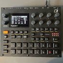Černý sampler Digitakt II s displejem a řadou ovládacích prvků. Na přístroji jsou viditelná tlačítka, otočné knoflíky a v pravém horním rohu logo Ele…
