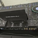 Černý DJ mixážní systém Denon DJ. Na zařízení jsou viditelné nápisy DENON DJ a PRIME. Součástí je kontroler s podsvíceným jog-wheelem, několik posuvn…