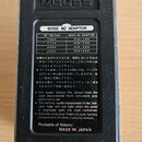 Zadní strana černého efektového pedálu s logem BOSS. Uprostřed je bílý štítek s nápisem BOSS AC ADAPTOR a tabulkou doporučených adaptérů pro různé na…