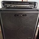 Černý basový zesilovač s hlavou a reproduktorovou skříní. Na hlavě je nápis GK GALLIEN-KRUEGER a označení modelu 700RB. Přední mřížka skříně je stříb…