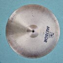Kruhové činely z kovu stříbrné barvy s viditelným broušením. Na povrchu je modrý nápis METEOR a menší texty Made in Germany, by MEINL a Crash 14. Pov…