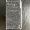 Černý kompaktní reproduktor s textilní mřížkou. Povrch mřížky vykazuje známky opotřebení ve formě několika světlých skvrn a nečistot. Na těle přístro…