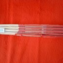 Sada dřevěných bubnových paliček zabalená v průhledné plastové fólii. Na červeném papírovém obalu je několikrát uveden nápis made by babex.eu a nečit…
