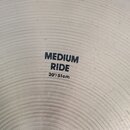 Detail stříbrného činchimu s viditelným koncentrickým broušením povrchu. Uprostřed je černý nápis MEDIUM RIDE a pod ním rozměr 20"/51cm. Povrch vykaz…