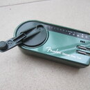 Zelený ladicí přístroj s nápisem Fender Chromatic Green Tuner™. Na horní straně je řada písmen C D E F G A B # a nápis CHARGE vedle symbolu baterie.…