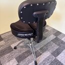 Černá polstrovaná židle s opěradlem a kovovým tříramenným podstavcem. Na spodní části sedáku je bílý nápis AHEAD SPINAL GLIDE. Opěradlo je zakončeno…