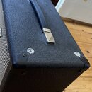 Černý kytarový kombo zesilovač s povrchem z texturovaného vinylu. Na horní straně je umístena černá plastová rukojeť s kovovými koncovkami. Rohy jsou…