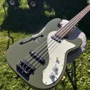 Kytara typu basová s olivově zeleným povrchem těla a světle šedým pickguardem. Nástroj má jeden hluboký výřez v těle (f-otvor) a dva černé snímače. N…