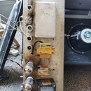Fotografie zachycuje vnitřní šasi kytarového zesilovače s viditelnými elektronickými komponenty. Jsou zde tři zapojené elektronky, transformátor a žl…