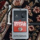 Kytarový efekt v šedém kovovém krytu s černým ovládacím panelem. Na panelu je nápis SMALL STONE, pod ním EH4800 PHASE SHIFTER a v dolní části logotyp…