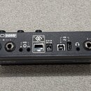 Zadní strana černého kompaktního syntetizátoru s nápisem MOD DWARF. Jsou zde vidět vstupy a výstupy označené jako 2 — IN — 1, MIDI IN a OUT, CONTROL…