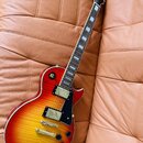 Elektrická kytara s trupem v červeno-žlutém sunburst provedení a viditnou strukturou dřeva. Na hlavě hmatníku je bílé logo Epiphone. Nástroj má dva h…