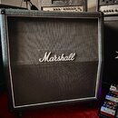 Černý kytarový kombozesilovač s bílým lemováním kolem přední mřížky. Uprostřed mřížky je umístěno bílé logo Marshall. Povrch je potahen černým textur…