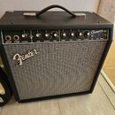 Černý kytarový kombo zesilovač s šedou síťovinou. Na předním panelu je nápis Fender a v pravém horním rohu označení Champion 40. Ovládací panel obsah…