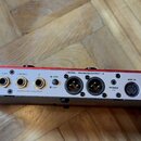 Zadávací panel stříbrného hudebního zařízení s červeným horním okrajem. Jsou zde viditelné nápisy: INPUT, AUX IN, RETURN, SEND, FX LOOP, L(MONO), R,…