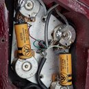 Fotografie zachycuje vnitřní elektroniku nástroje s několika součástkami a zapojením kabelů. Jsou vidět dva žluté válcové kondenzátory s nápisy „Pape…