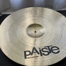 Kruhový činely z žlutého kovu s viditelným koncentrickým rýhováním povrchu. Ve spodní části je černý nápis pAiste a pod ním menší text MADE IN SWITZE…