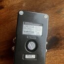 Spodní strana černého kytarového efektu s bílými gumovými nožičkami. Na štítku je uveden text MUSIC Tribe Brands UK LTD., logo tc electronic a nápis…