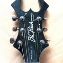 Černá hlava elektrické kytary s výrazným, ostře zakončeným tvarem. Na povrchu je bílý nápis B.C. Rich, N.J. Series a v dolní části označení WARLOCK.…