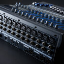 Černý mixovací pult s modrými detaily a řadou šedých ovrtovných knoflíků. Na horní hraně je nápis PreSonus a na boku STUDIOLIVE 1608S. Zadní panel ob…
