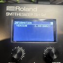 Černý syntetizátor s nápisem Roland SYNTHESIZER SH-4d. Modrý displej zobrazuje text INFORMATION 1 a VERSION 2.00(0062). Jsou vidět ovládací knoflíky…