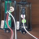 Dvě černé plastové krabičky s elektronickými obvody a připojeným kabelážím. Na levé je vidět nápis 2018 2504 145 IS2, logo CE a nápis Seymour Duncan…