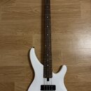 Bílá elektrická basová kytara s tmavým hnedým hmatníkem. Na hlavě je viditelné logo Yamaha. Nástroj má dva černé humbuckery, tři černé ovládací knofl…