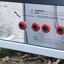 Detail zadní strany přístroje s nápisem MODEL: 2555X a kovovým krytem. Jsou zde vidět čtyři červené konektory pro reproduktory s nápisy LOUDSPEAKERS,…
