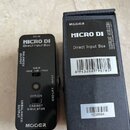 Černý Direct Input Box značky MOOER s nápisem MICRO DI. Zařízení má přepínače GAIN (-20dB, 0dB, +20dB), OFF/ON u CABINET SIMULATOR a GND LIFT. Na bok…