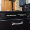 Černý zesilovač v texturovaném pouzdře s nápisem FBT elettronica. Na předním panelu je vypínač, vstup pro napájení a varovný text začínající slovem I…