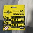 Žluté balení kytarových strun s nápisy ROTO SOUND, REGULAR NICKEL ON STEEL a ELECTRIC GUITAR STRINGS. Jsou zde uvedeny kalibry 10 13 17 26 36 46 a vý…