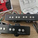 Dvě černé elektrické kytarové snímače značky DiMarzio. Oba mají plastový kryt s šesti viditelnými póly a připojovací kabely v různých barvách. Vedle…