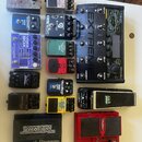 Sestava různých kytarových efektů a pedálů. Jsou zde zařízení s nápisy: „BASEBALLS“, „ DigiTech Whammy“, „Boss Metal Zone MT-2“, „BOSS TU-3“, „TC Ele…