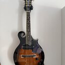 Černá mandolina s tělem v přechodové hnědo-černé barvě (sunburst) a f-otvory. Na hlavě je bílý nápis Harley Benton a dekorativní ornament. Nástroj má…