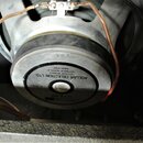 Fotografie zachycuje zadní stranu reproduktoru s kovovým magnetem a připojenými vodiči. Na štítku je uveden nápis ROLLAR CELECTION LTD., DITHON WORKS…