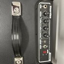 Černý basový kombo zesilovač s nápisem Hartke a označením HD50. Ovbedací panel obsahuje vstup INPUT, čtyři otočné potenciometry VOLUME, BASS, MID a T…