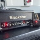 Černý kytarový zesilovač s nápisem Blackstar na předním panelu. Pod logem se nachází ovládací prvky s nápisy POWER, STANDBY, HT 5, REVERB (LEVEL), EQ…