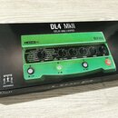 Zelený efekt pedál Line 6 DL4 MkII v černé kartonové krabici s nápisem DL4 MkII DELAY AND LOOPER. Na pedálu jsou čtyři ovládací knofíky s popisky TIM…