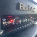 Kytarový zesilovač značky Blackstar s nápisem HT 5. Na předním panelu jsou přepínače POWER a STANDBY s označením ON, kontrolka a řada ovládacích knof…