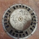 Zadní strana reproduktoru s kovovým rámem a magnetem. Na povrchu magnetu je ručně napsáno „4Ω“ na dvou místech. Povrch kovu vykazuje známky opotřeben…
