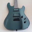 Tmavě zelená elektrická kytara s dvojstupňovými humbuckery a černým hardwarem. Na těle jsou dva ovládací knofíky a přepínač zvuků. Povrch laku je hla…