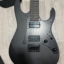 Černá elektrická kytara s matným povrchem a dvěma humbuckery. Na těle nástroje nejsou žádné viditelné značky ani názvy modelů. Kytara je vybavena dvě…