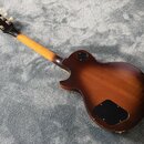 Zadní pohled na elektrickou kytaru s hnědým gradientním lakem (sunburst). Na zadní straně těla jsou dvě černé krytky elektroniky. Kytara vykazuje zná…